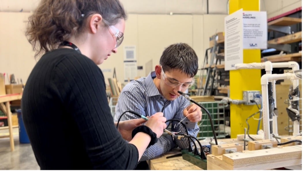Interns Anna Biolchini and Carson Archuleta soldering connectors for the separation bolt system to be utilized on this year’s rockets. 