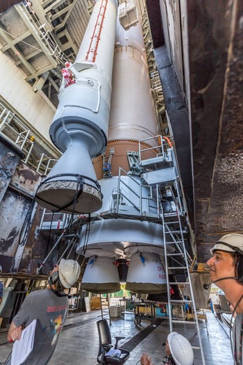 A solid rocket booster is lowered into position for installation. Photo by United Launch Alliance