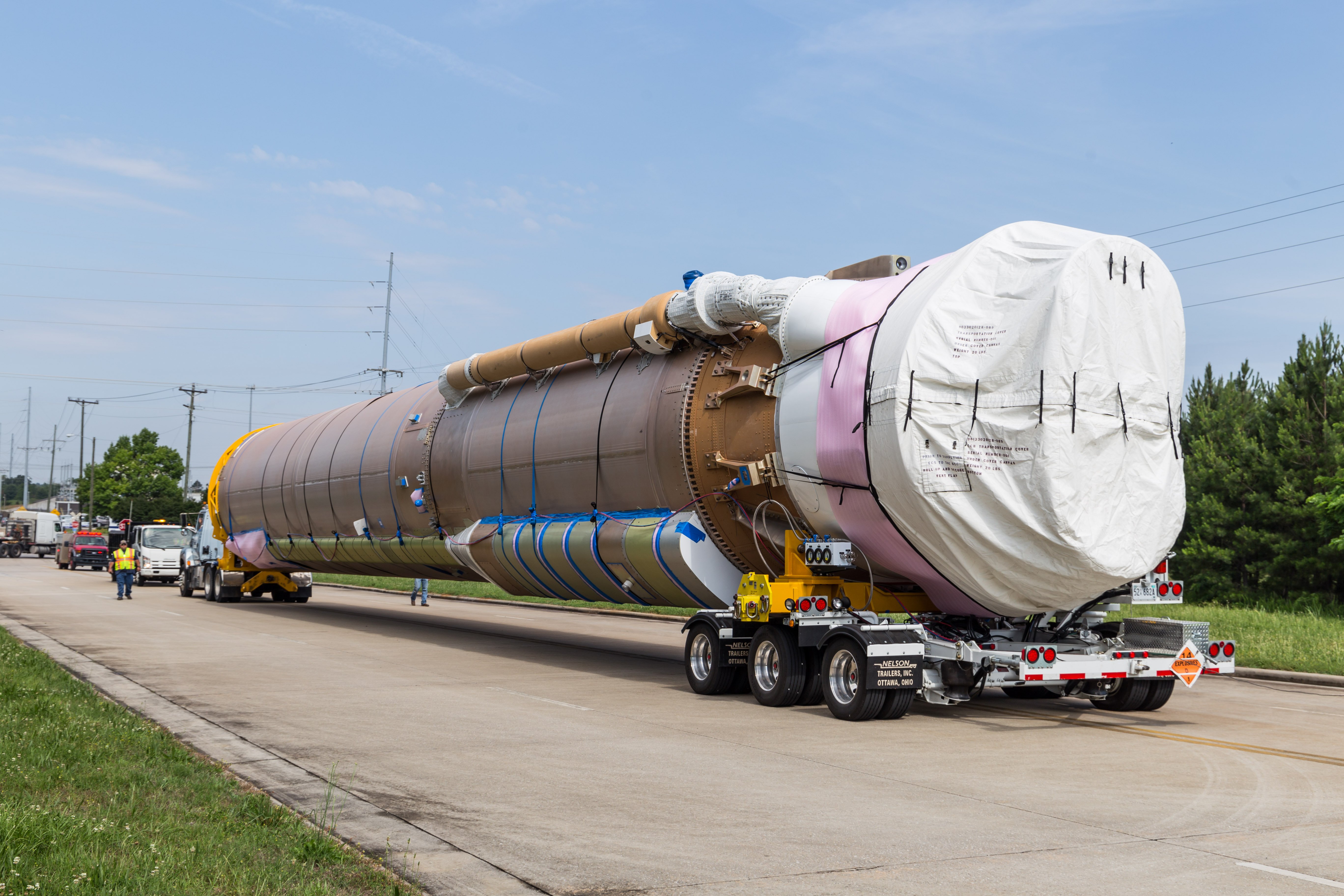 The Atlas first stage for CFT travels down the road the Decatur dock. Photo by ULA